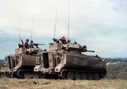 Colour photo of two tracked military vehicles