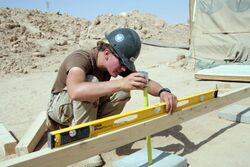 US Navy 080606-N-9623R-414 Builder 2nd Class Kathryn Henderson, assigned to Naval Mobile Construction Battalion (NMCB) 3, uses a horizontal level and tape measure.jpg