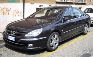 Front-three-quarter view of a four-door car with door mirrors, flush headlights, front foglamps, door mirrors, and alloy wheels