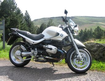 Side view of a silver BMW R1150R on the road side