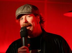 A 2008 photograph of actor John DiMaggio, speaking into a microphone