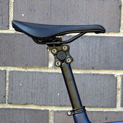 A bicycle suspension seatpost with a mounted saddle.