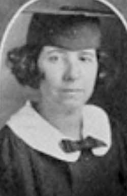 A young white woman with bobbed curly hair, wearing an academic mortarboard cap and gown, with a round white collar
