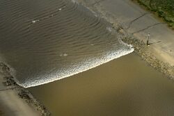 A tidal bore wave moves along the River Ribble between the entrances to the Rivers Douglas and Preston.