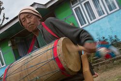 An aged man playing Chyabrung Drum, Yuksom, West Sikkim, India.jpg