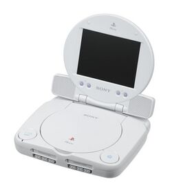 A photo of a PS One console against a pure white background with a 5-inch LCD screen attachment placed on top.