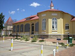 A red-roofed yellow building in bright sunlight, built in German colonial style. Over the entrance is a red cross and the inscription "Elisabeth Haus"