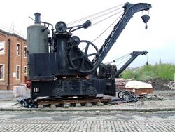 A railway-mounted steam crane, with a vertical boiler mounted at the rear of the crane platform.
