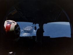 Colour photograph of an aircraft carrier viewed from the cockpit of an aircraft