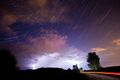 The constellation of Cassiopeia over a thunderstorm.