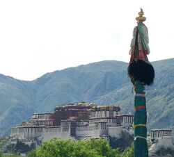 Dhvaja (pole with silk scarfs), overlooking Potala White Palace.jpg