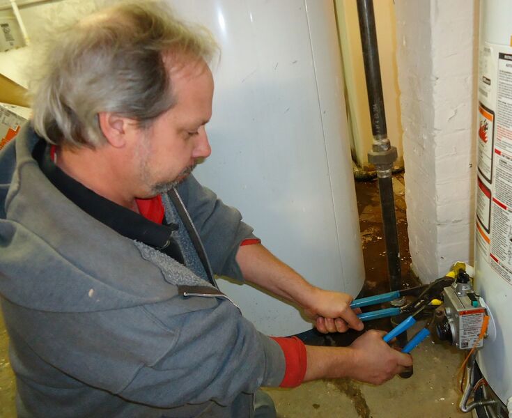 File:Plumber uses two wrenches to tighten a fitting.jpg