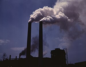 Smokestacks from a wartime production plant releasing pollutants into the atmosphere
