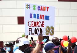 Protester holding up a sign reading # I can't breathe George Floyd '93
