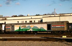 A railway baggage car painted with a mural of mountains