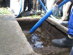 Demonstration of pumping faecal sludge from a "wet" VIP pit (8152015980).jpg