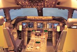 Cockpit of modern jet airliner, showcasing digital displays and instruments. Light enters through the windshield.