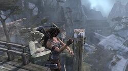 The player character, standing atop a high ledge, creating a makeshift zipline to a lower ledge by shooting an arrow.