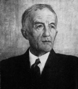 A black and white portrait of an older gentleman with a receding hairline wearing a suit and tie.