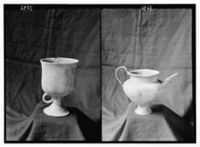 Monochromatic image of an alabaster vase with an inscribed lid and a silver pot