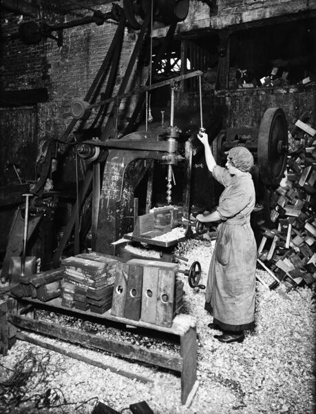 File:Woman operating boring machine; boring wooden reels for winding barbed wire.jpg
