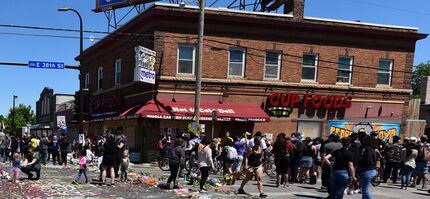 Corner store near site of Floyd's murder with crowd of protesters