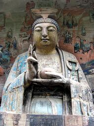 Buddha image gesturing, and surrounded by reliefs depicting stories