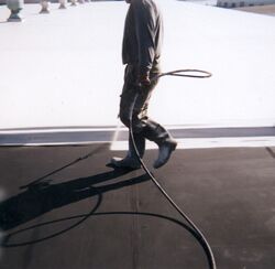 Top coating a commercial flat roof