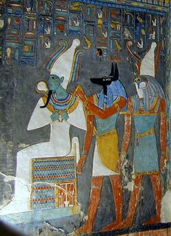 Painted relief of a seated man with green skin and tight garments, a man with the head of a jackal, and a man with the head of a falcon