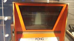 A horizontal photograph showing the top half of an orange arcade cabinet.