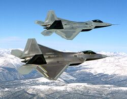 Two F-22s overflying snow-capped mountains.