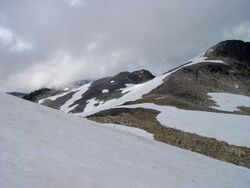 Rugged landscape of rubble covered with snow on a cloudy day.