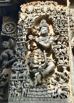 12th-century Krishna playing flute with gathered living beings lost in music at Shaivism Hindu temple Hoysaleswara arts Halebidu Karnataka India.jpg