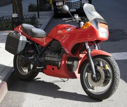 Red BMW K75S with top box and panniers, parked on a city street