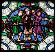 A detail from an ancient stained glass window shows Becket being murdered by several men.