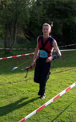 Run archer with recurve bow and back quiver during a competition.JPG