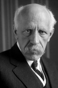 Nansen shown in later years with white, receding hair; characteristic drooping white mustache; and intensely focused eyes.