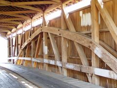 Interior structure of a covered bridge utilizing a kingpost with a Burr Arch structure