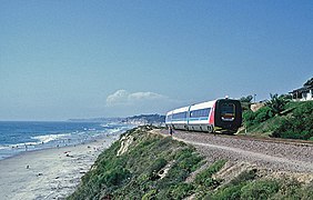 A passenger train with blue and black stripes and red ends