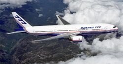 Side view of twin-engine jet in flight, surrounded by white clouds