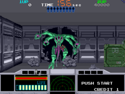 Horizontal rectangle video game screenshot that is a digital representation of a grey room on a space ship. Centered is a green and purple, multi-limbed alien bursting through the wall of a dark corridor.