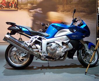 Blue BMW K1200R indoors with a promotional display in the background