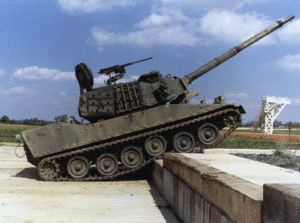 An M8 AGS climbs a vertical wall at a test track. Mounted at the commander's station is an M2 Browning .50 caliber machine gun