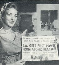 Smiling woman displaying newspaper headline