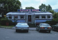 A restaurant with the sign "Collin's Diner". Two cars are parked at the front.