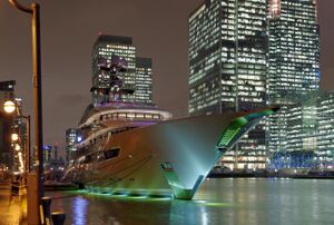 A ship at dock backlit by skyscrapers