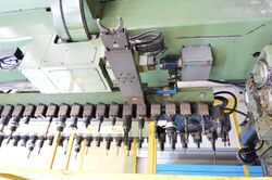 A chain type automatic tool changer with swiveling arm and two grippers, installed on a mill