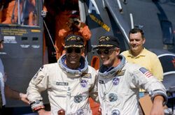 Astronauts Pete Conrad (right) and Richard Gordon pose in front of the recovery helicopter.jpg