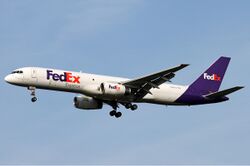 Side view of twin-jet aircraft in flight, showing "FedEx" lettering
