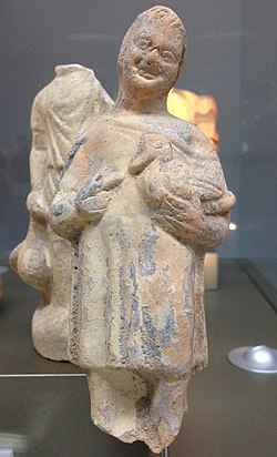 Terracotta statuette of a standing male child holding a fowl, presumed to be a duck.